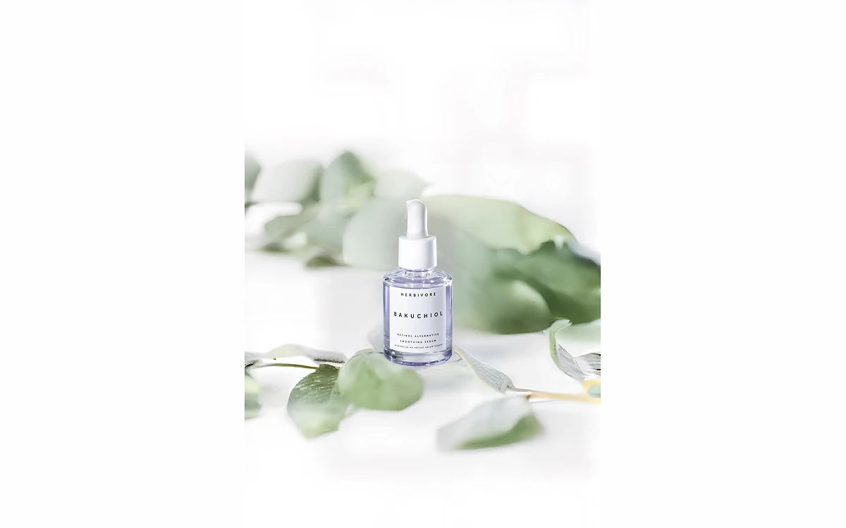 Mokker example output of a serum bottle surrounded by eucalyptus leaves on a soft studio background