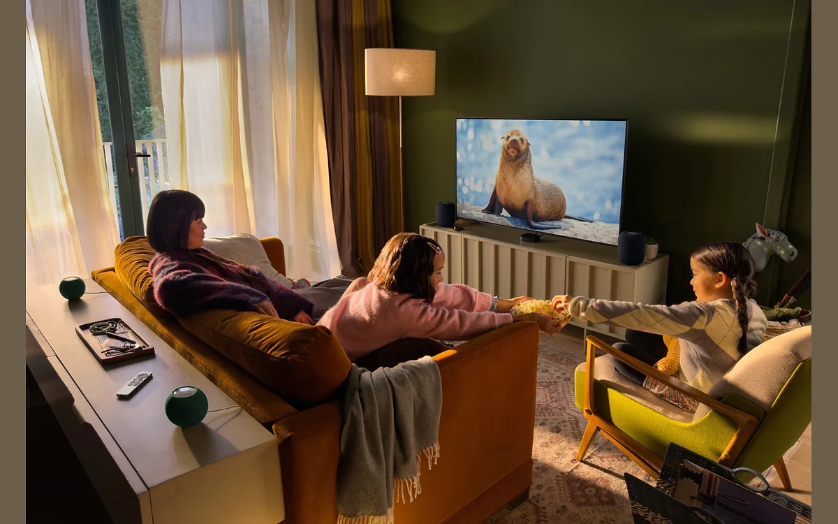 Family watching TV in a living room set up with the new Apple TV 4K and HomePod speakers