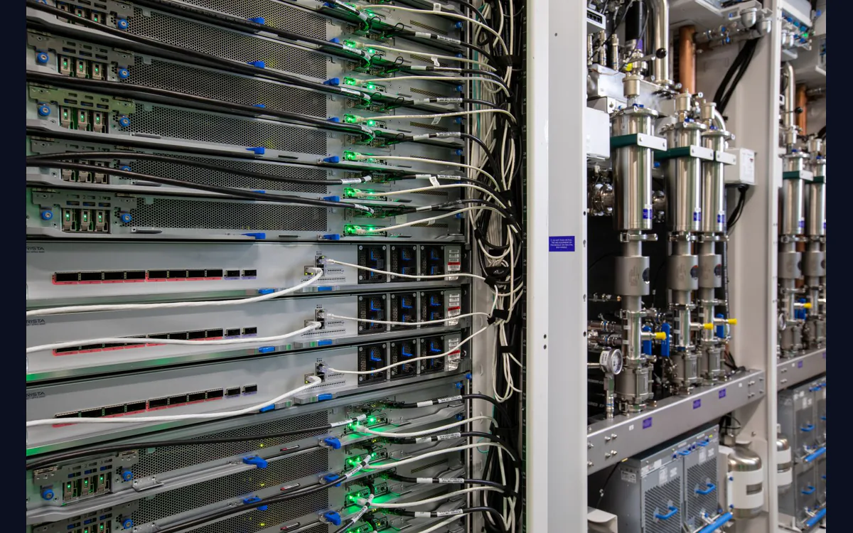 Close-up of Maia server racks in a Microsoft datacenter with cabling, green indicator lights and cooling pipes